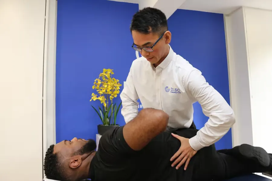 Dr Ka Kin Lee adjusting a patient's lower back